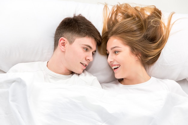 La giovane coppia adorabile che giace in un letto