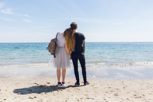 La giovane coppia sta levandosi in piedi vicino al mare