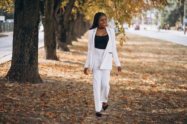 La giovane donna africana si è vestita in vestito bianco in parco