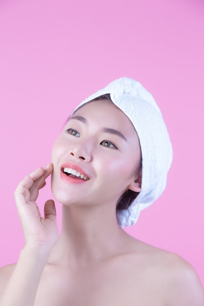 La giovane donna Asia con la pelle pulita fresca tocca il proprio fronte, espressioni facciali espressive, cosmetologia e stazione termale.