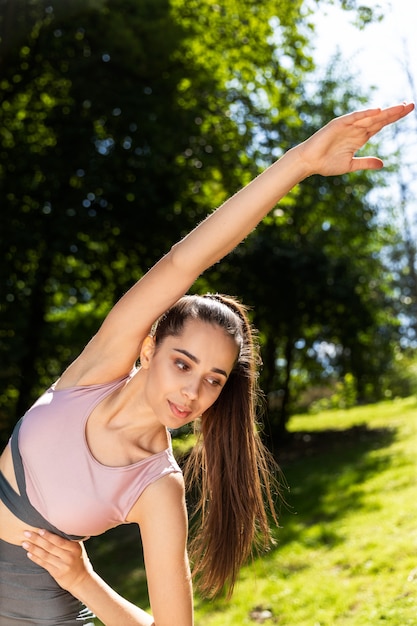 La giovane donna atletica sta allungando all'aperto