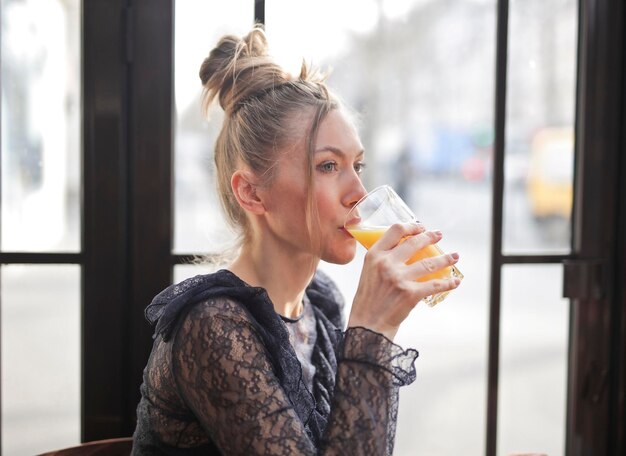 la giovane donna beve un bicchiere di aranciata