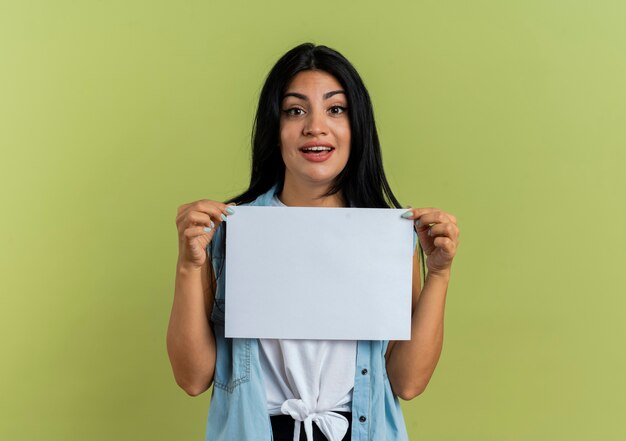 La giovane donna caucasica sorpresa tiene il foglio di carta