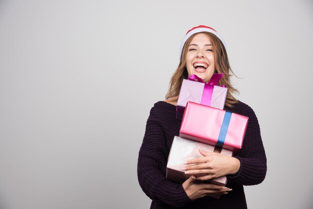 La giovane donna con i regali della tenuta del cappello di Santa presenta.