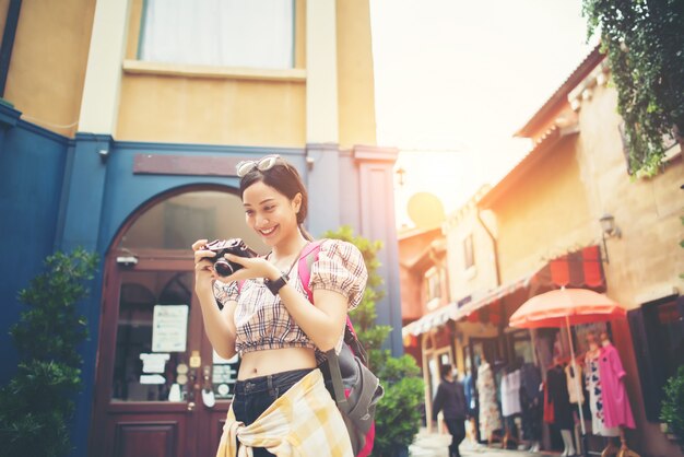 La giovane donna dei pantaloni a vita bassa gode di di prendere la foto in urbano mentre viaggiava.