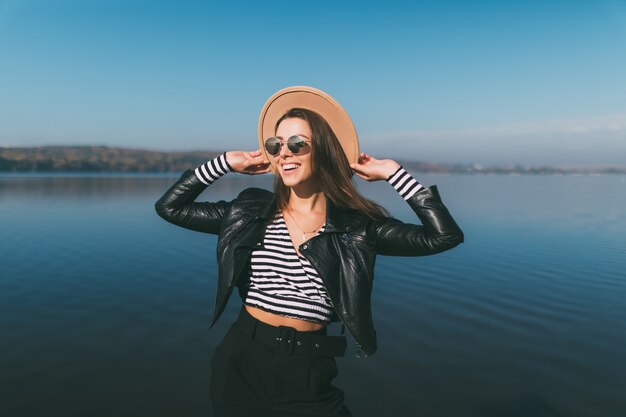 La giovane donna della ragazza di modello che posa nel giorno di autunno al lungomare del lago si è vestita in abiti casual