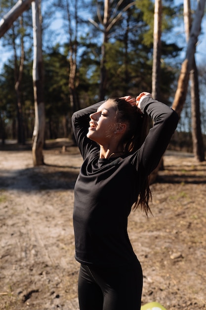 La giovane donna di forma fisica cammina nel parco