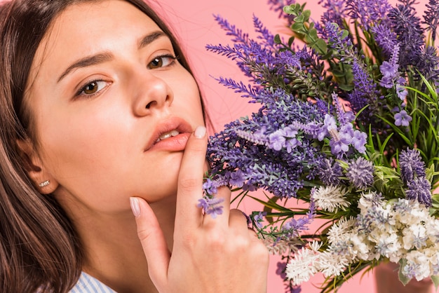 La giovane donna di pensiero che tiene il mazzo di fiori si avvicina al fronte