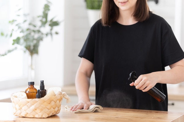 La giovane donna pulisce la cucina con prodotti ecologici