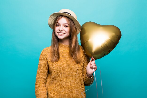 La giovane donna riceve il baloon dell'aria sulla celebrazione di anniversario isolata sopra la parete di colore