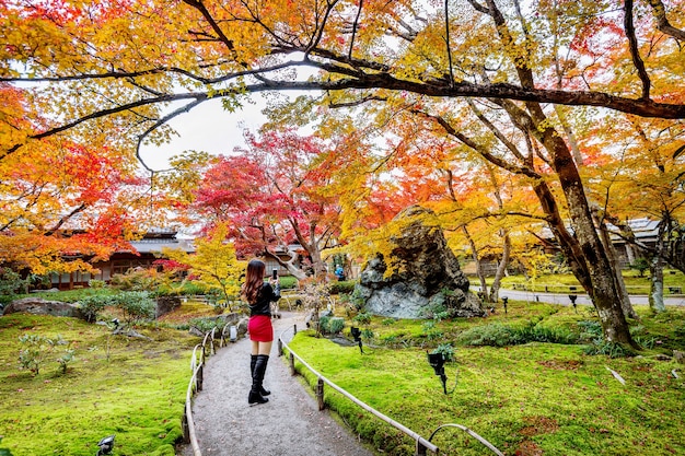 La giovane donna scatta una foto nella sosta di autunno. Foglie colorate in autunno, Kyoto in Giappone.