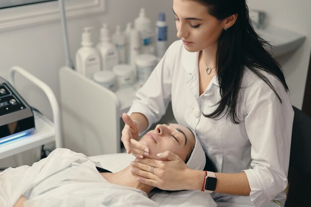 La giovane donna si trova con gli occhi chiusi, procedura di fabbricazione cosmetologo