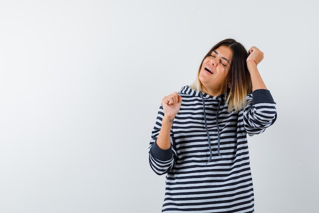 La giovane donna sta ballando su sfondo bianco