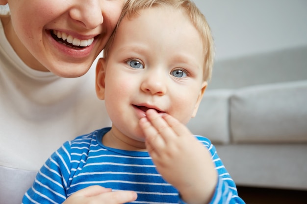 La giovane madre con il suo piccolo figlio di un anno vestito in pigiama sta proponendo