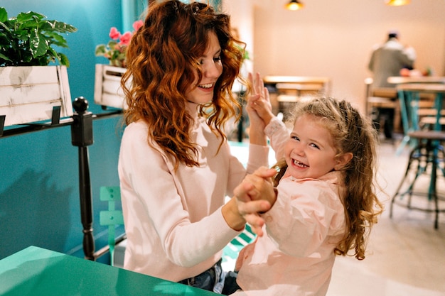 La giovane madre dai capelli rossi con il suo adorabile bambino riccio trascorre il fine settimana in famiglia