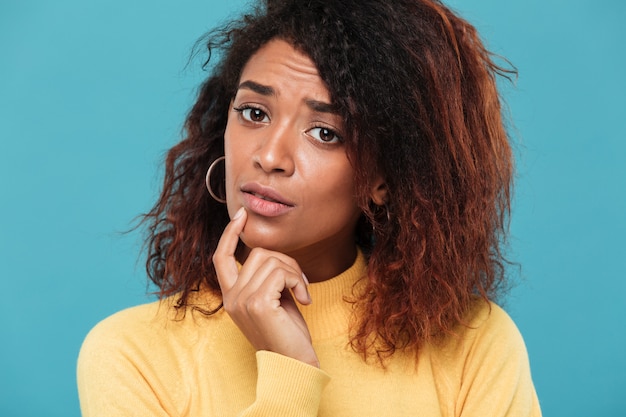 La giovane signora africana confusa si è vestita in maglione caldo