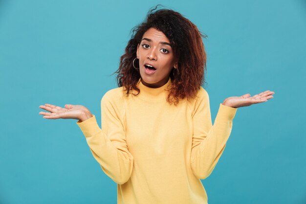 La giovane signora africana confusa si è vestita in maglione caldo