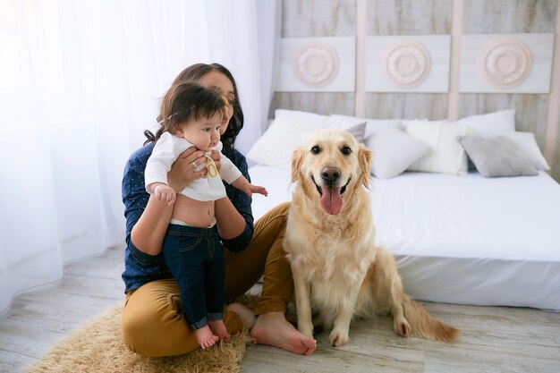 La madre abbraccia la figlia e si siede vicino al cane