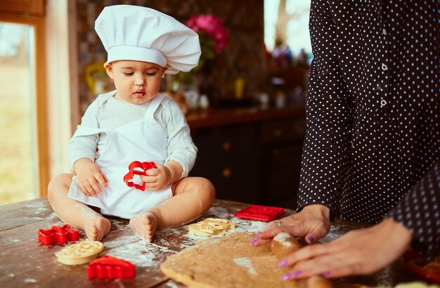 La madre con il figlio impasta l&#39;impasto in cucina