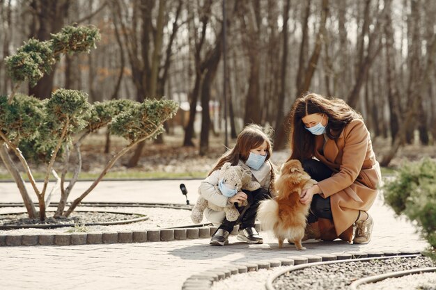 La madre con la figlia cammina fuori in maschere