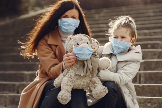 La madre con la figlia cammina fuori in maschere