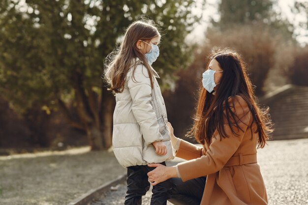 La madre con la figlia cammina fuori in maschere