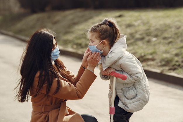 La madre con la figlia cammina fuori in maschere