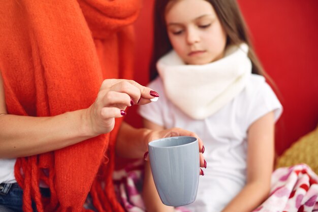 La madre dà a sua figlia malata il tè caldo