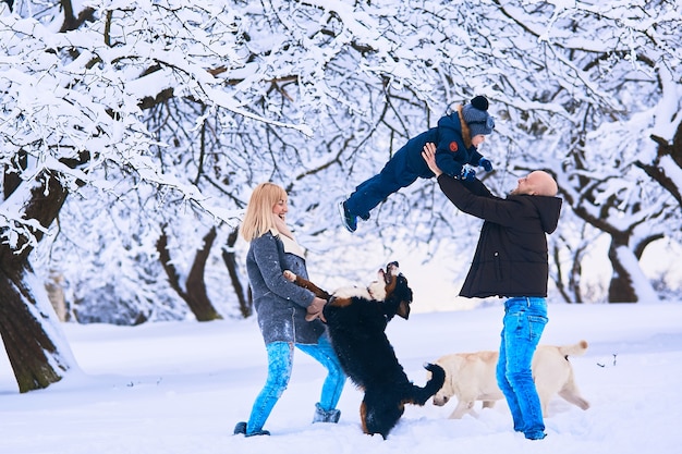 La madre, padre e figlio che giocano con i cani