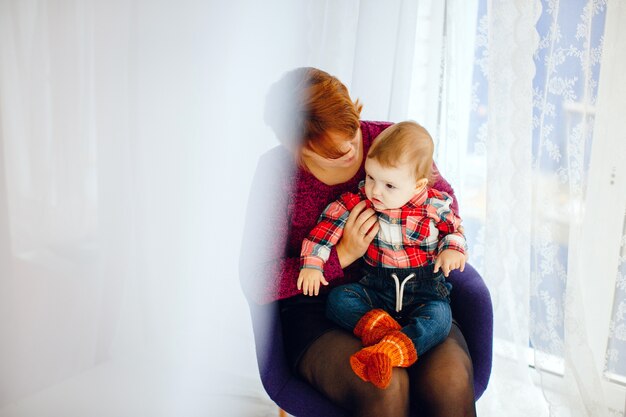 La madre si siede con la piccola figlia prima della finestra