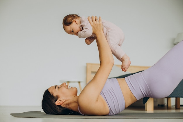 La mamma con la sua bambina pratica lo yoga a casa
