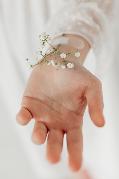 La mano con i fiori della molla si chiude su