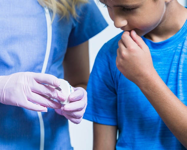 La mano del dentista che mostra i denti intonacano la muffa al ragazzo