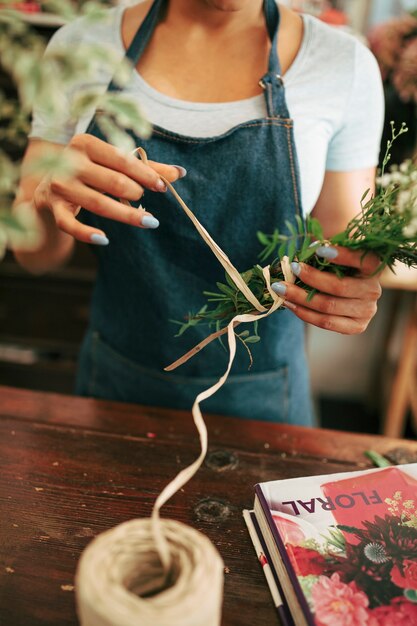 La mano del fiorista che fa un mazzo di fiori