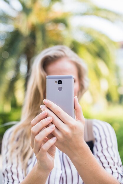 La mano della donna che cattura auto ritratto da smart phone