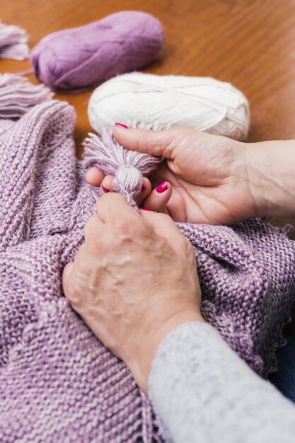 La mano della donna che fa la nappa di lana