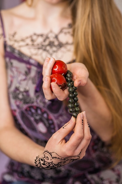 La mano della donna che tiene il braccialetto cinese rosso delle sfere e delle zen dei branelli