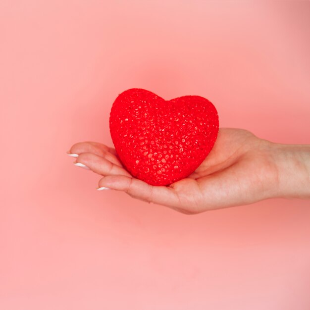 La mano della donna con cuore decorativo