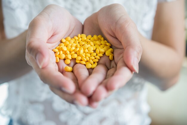 La mano della donna versa le pillole della medicina dalla bottiglia