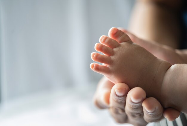 La mano della madre adornava i piedi del neonato.