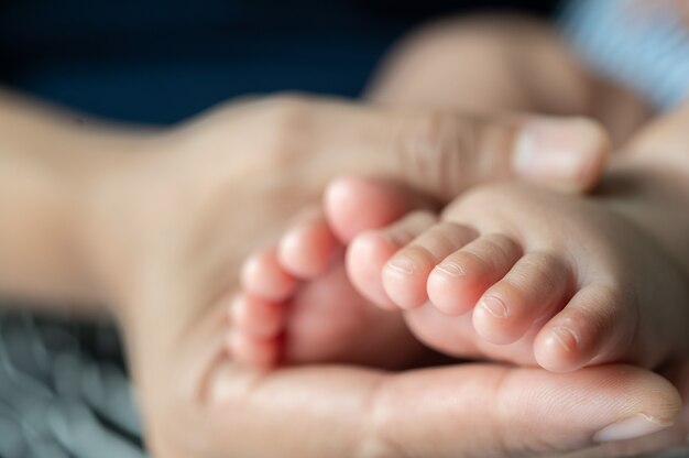 La mano della madre adornava i piedi del neonato.