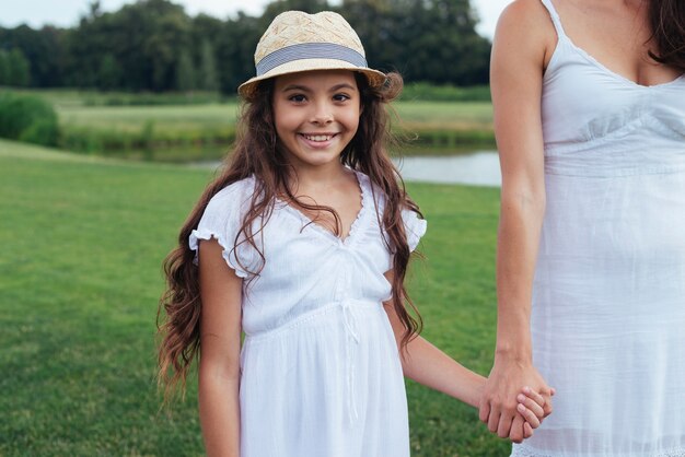 La mano della madre della tenuta felice della ragazza all&#39;aperto