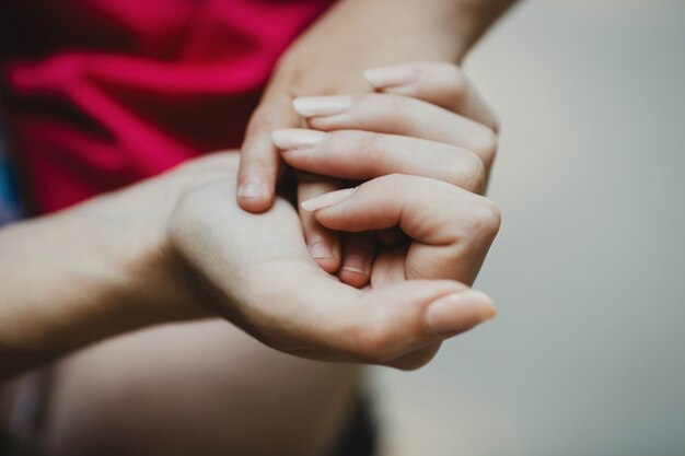 La mano della madre tenera tiene le dita dei bambini sul palmo