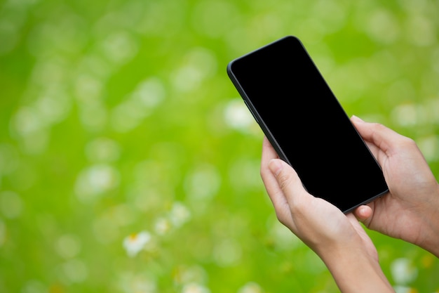 La mano della ragazza che tiene uno smartphone