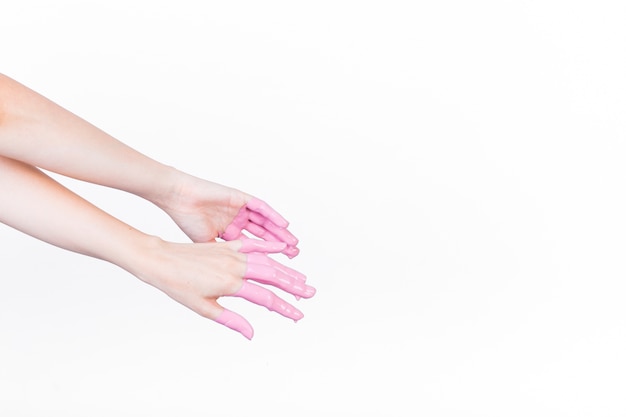 La mano di una persona con vernice rosa su sfondo bianco
