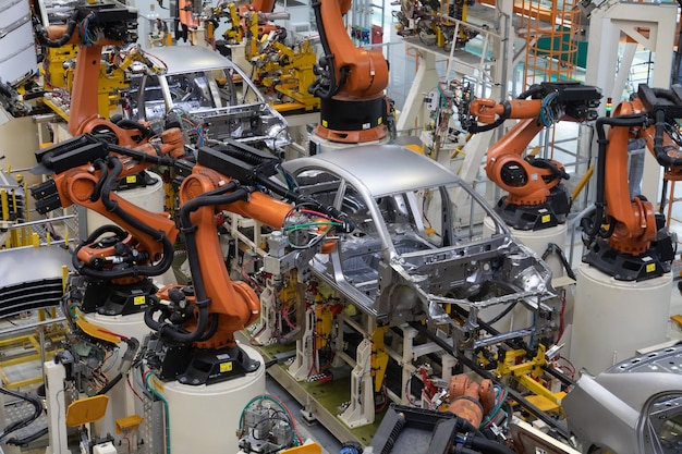 La moderna tecnologia di assemblaggio di automobili L'impianto dell'industria automobilistica Negozio per la produzione e l'assemblaggio di macchine vista dall'alto Il processo di saldatura di parti dell'auto