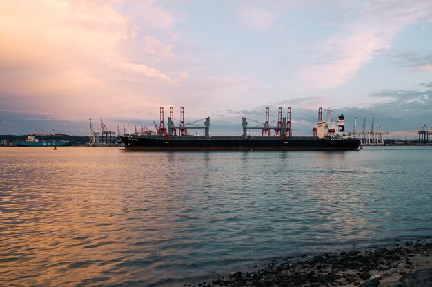 La nave da carico ha parcheggiato al porto un giorno soleggiato durante il tramonto