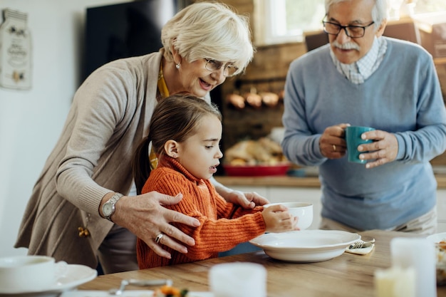 La nipote aiuta la nonna ad apparecchiare la tavola per il pranzo