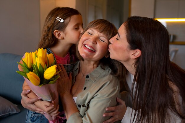 La nonna viene baciata sulla guancia dalla famiglia