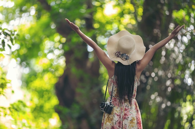 La parte posteriore della ragazza felicità indossando un cappello di paglia in giardino